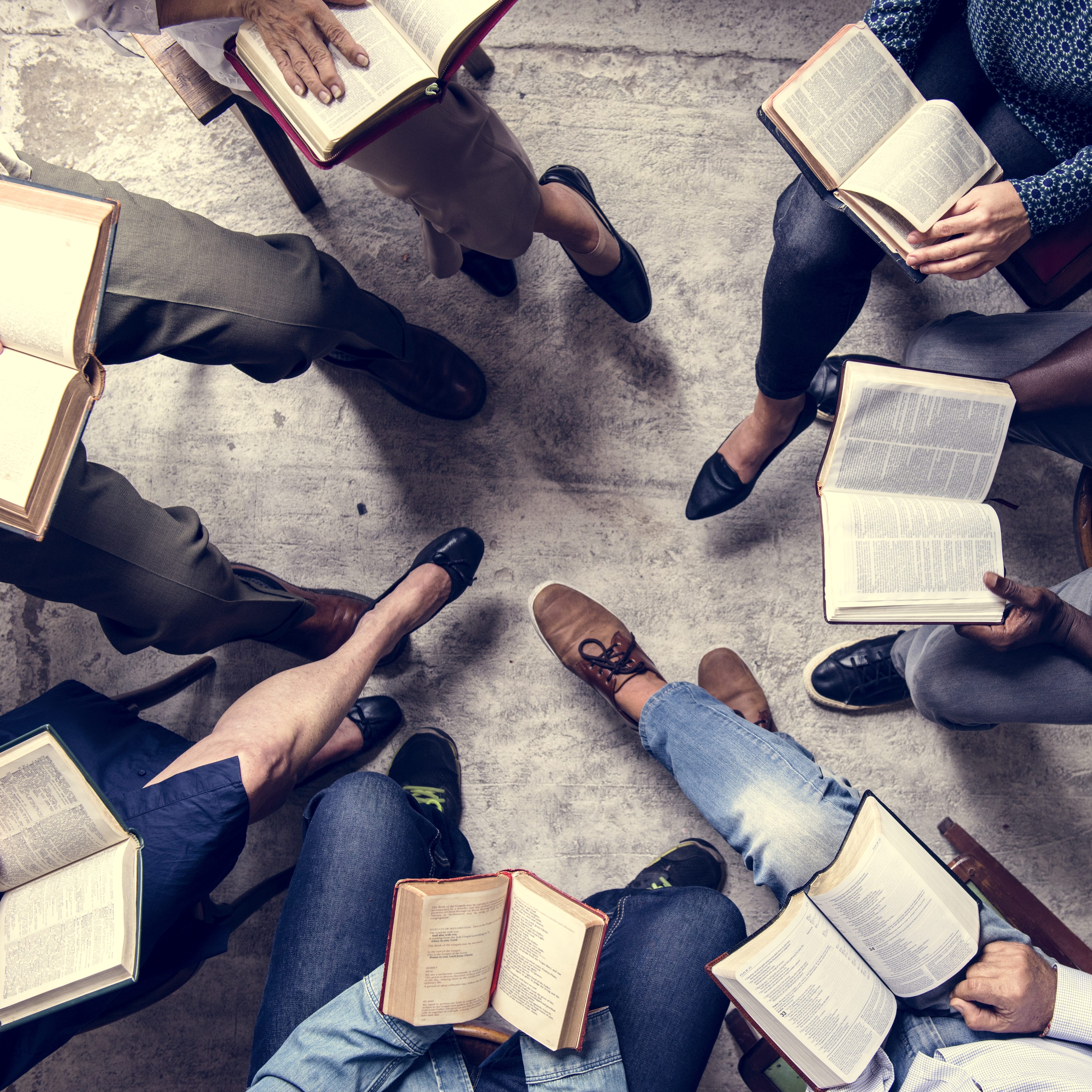 View from overhead of a book group sitting in a circle reading.