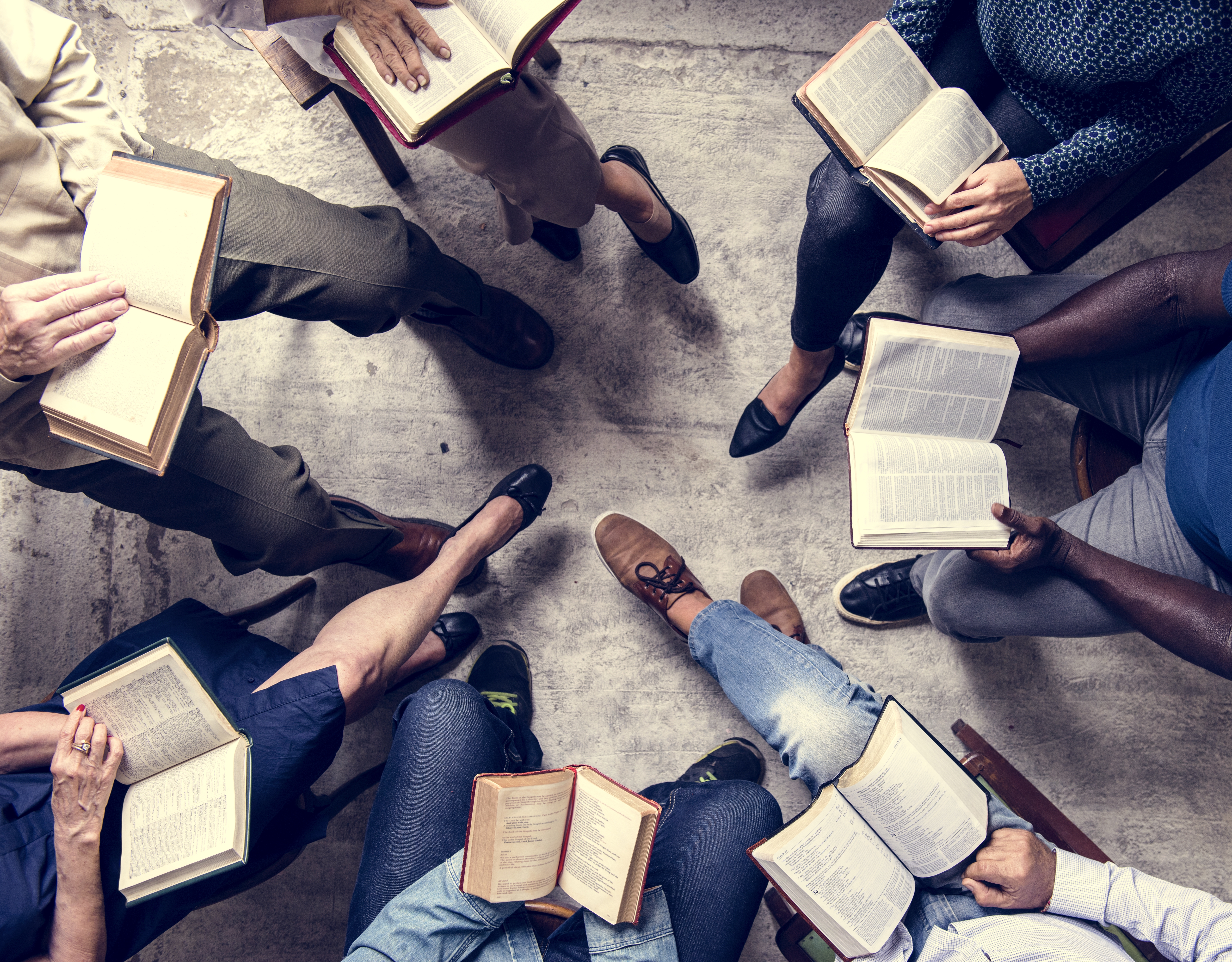 View from overhead of a book group sitting in a circle reading.